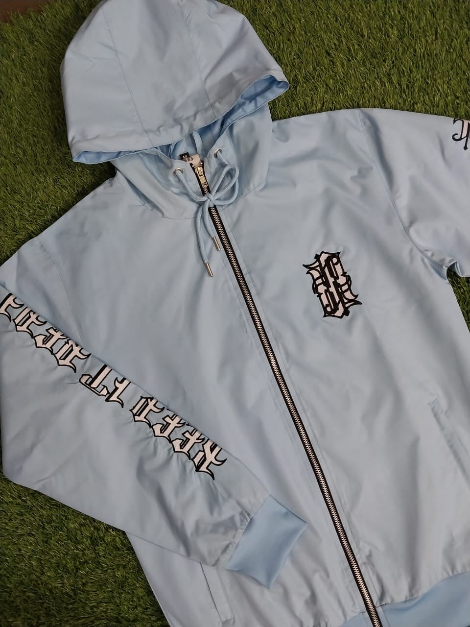 the baby blue ‘keep it real’ windbreaker