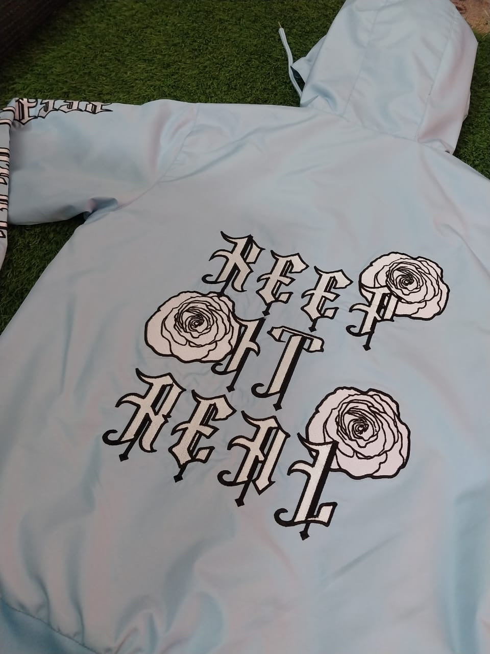 the baby blue ‘keep it real’ windbreaker